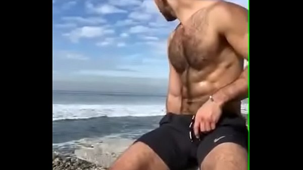 Gostoso batendo punheta na praia
